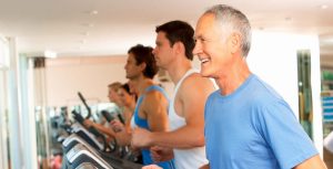 Men of all ages protecting their health with exercise on a treadmill at a gym as part of men's health services